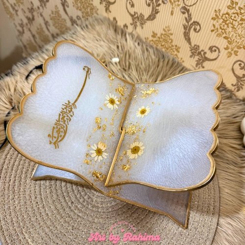 Close-up of translucent white floral resin Quran stand with Bismillah design